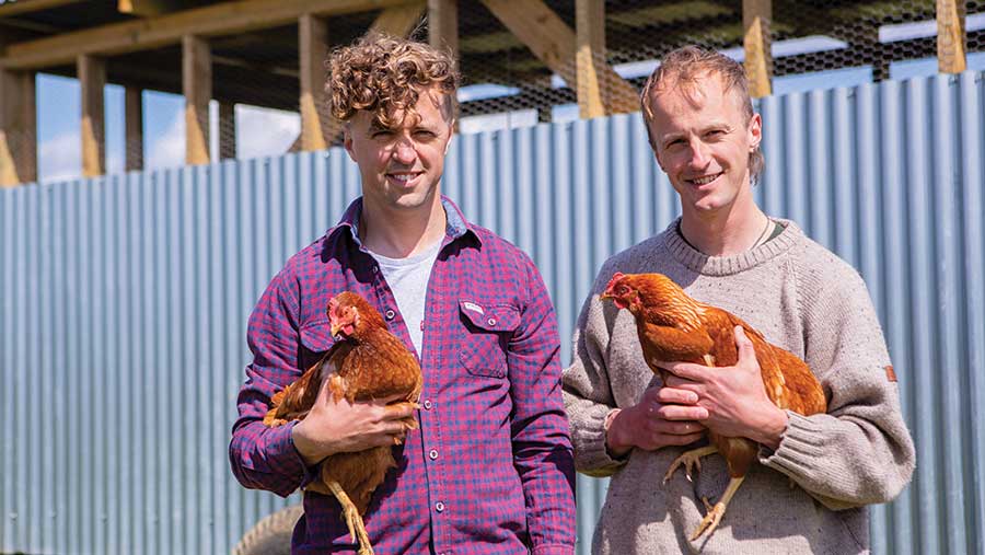Two men, each holding a chicken